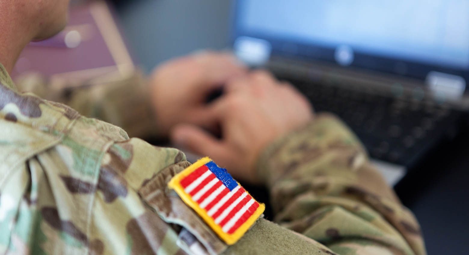 unrecognizable American soldier writing on a laptop