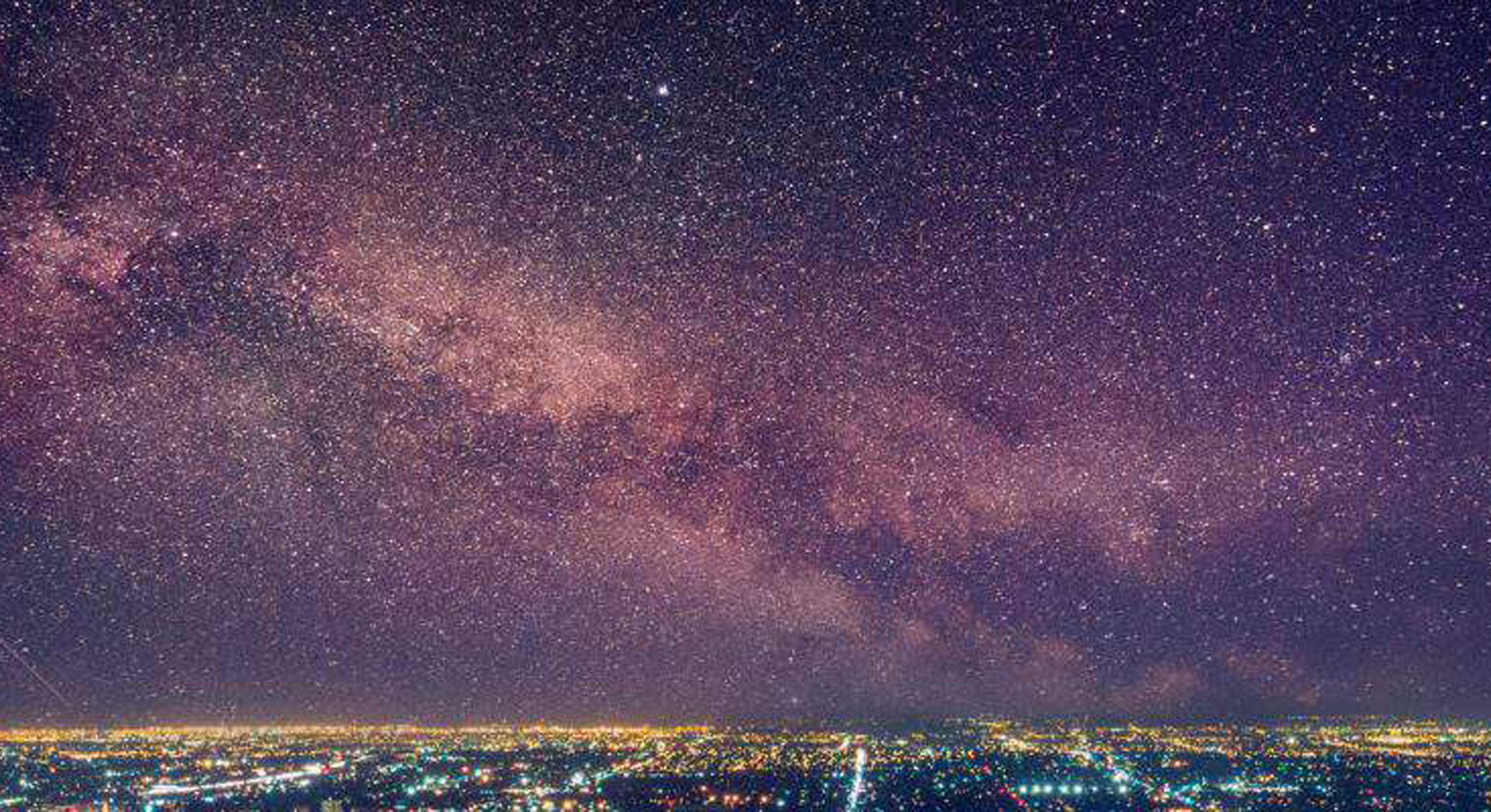 Sky with stars above city lights 