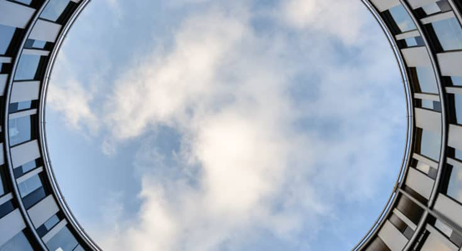 View of clouds from below through round building 